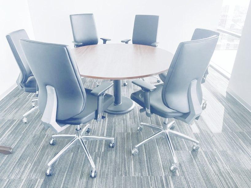 Sala de reuniones con mesa redonda y sillas ejecutivas Dismardi