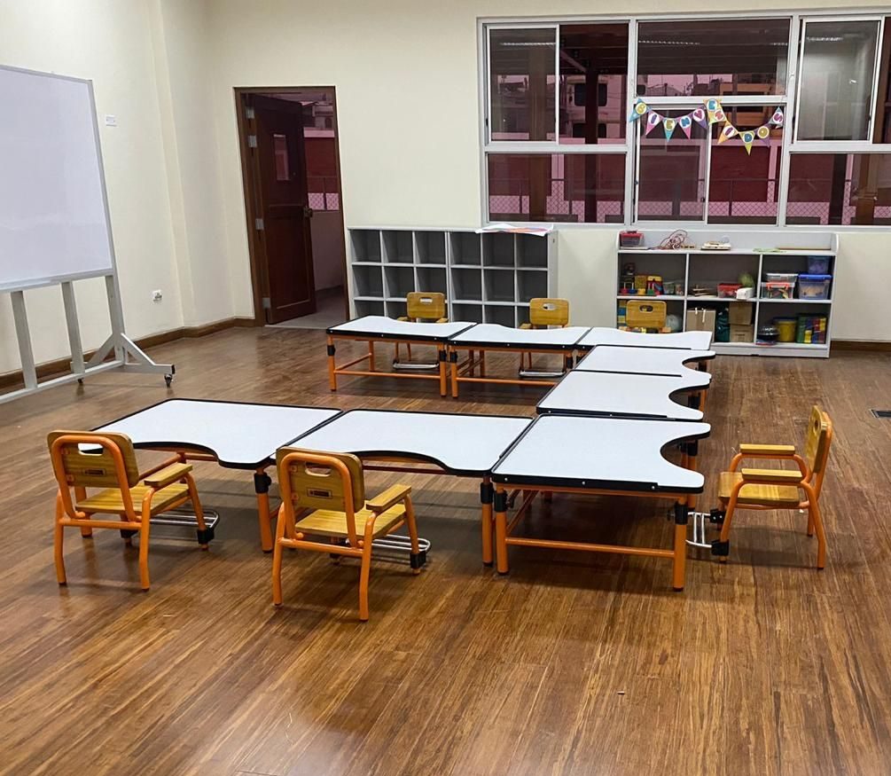 Aula infantil con mesas y sillas modulares de estructura naranja Dismardi