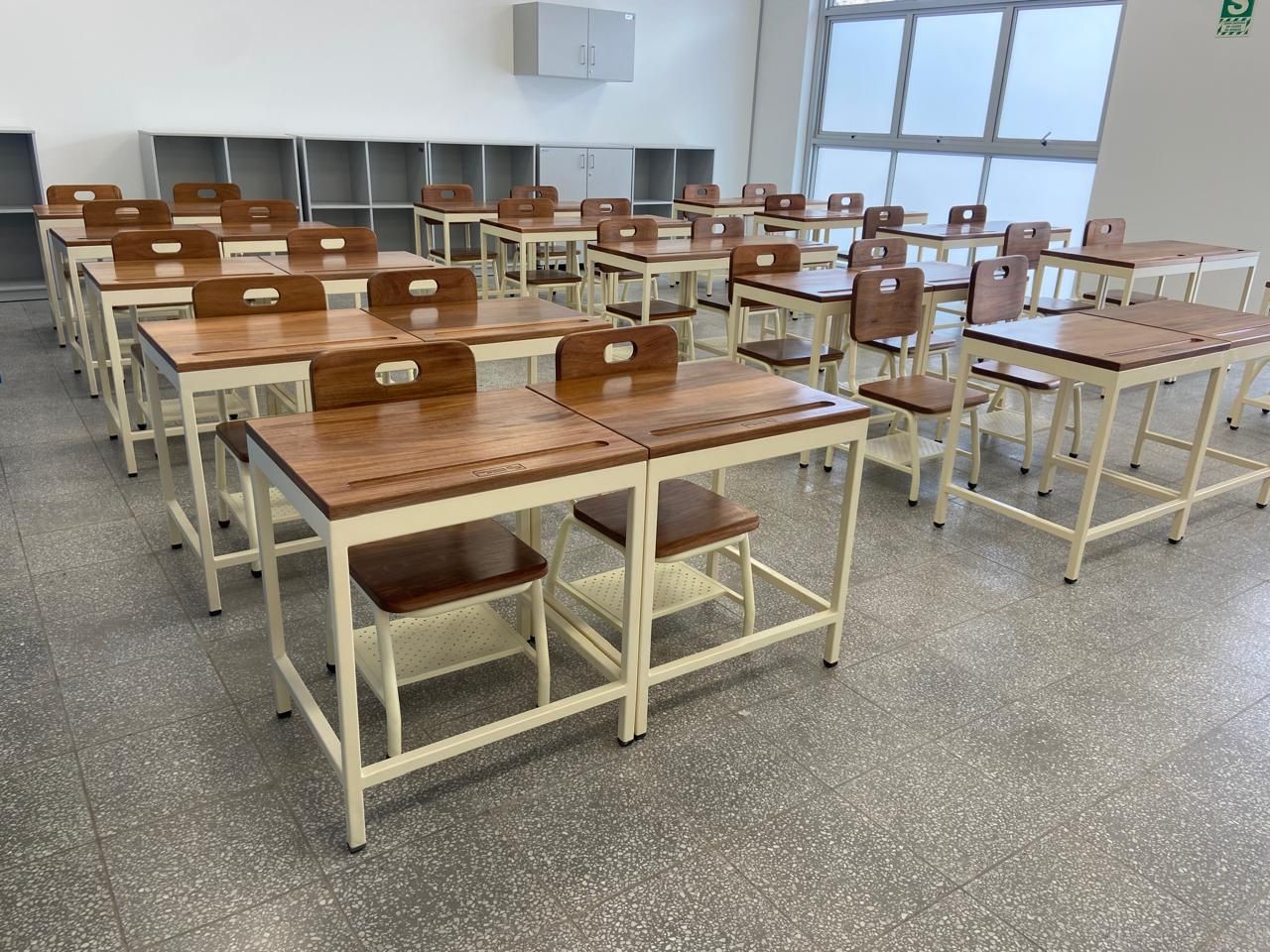 Aula equipada con mesas y sillas escolares de estructura crema Dismardi