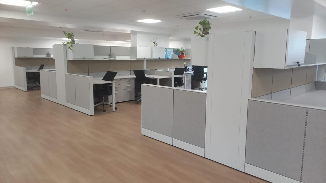 Oficina abierta con puestos de trabajo modulares y separadores de melamina